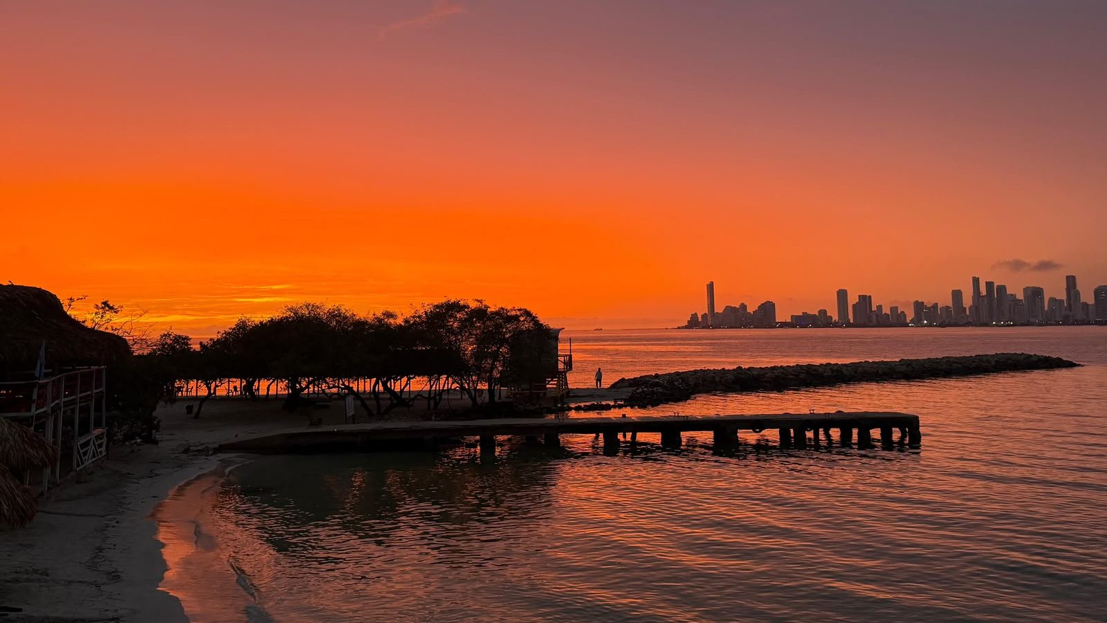 Un magnifique coucher de soleil sur la côte caraïbe, avec les lumières de la ville à l’horizon.

Photographie personnelle — © [Valeria Barreto], 2026