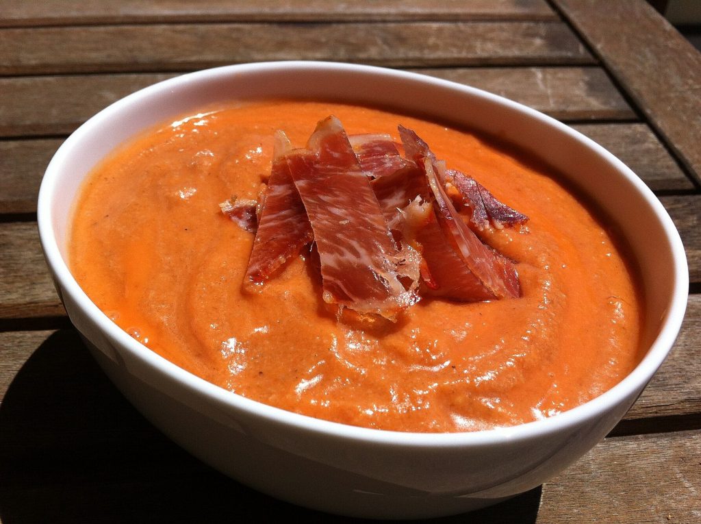 Salmorejo cordouan servi dans un bol blanc, garni de jambon : l'une des recettes andalouses faciles présentées ici.
