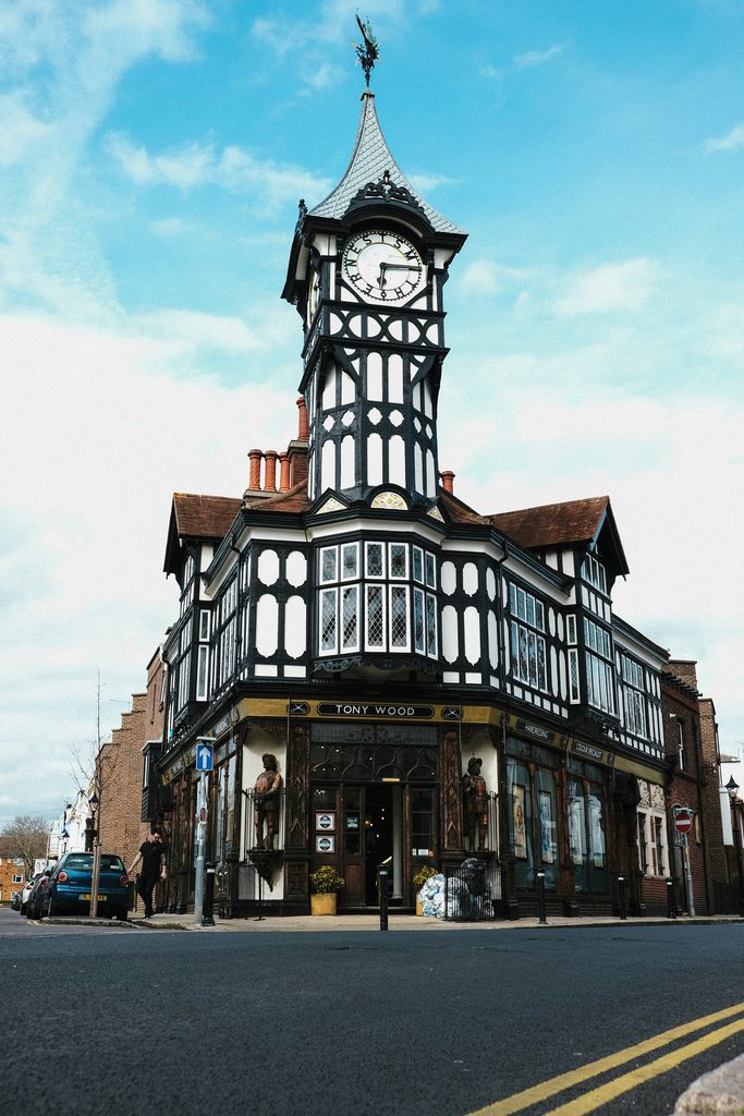 Bâtiment à colombage avec une horloge au-dessus d'un commerce. 